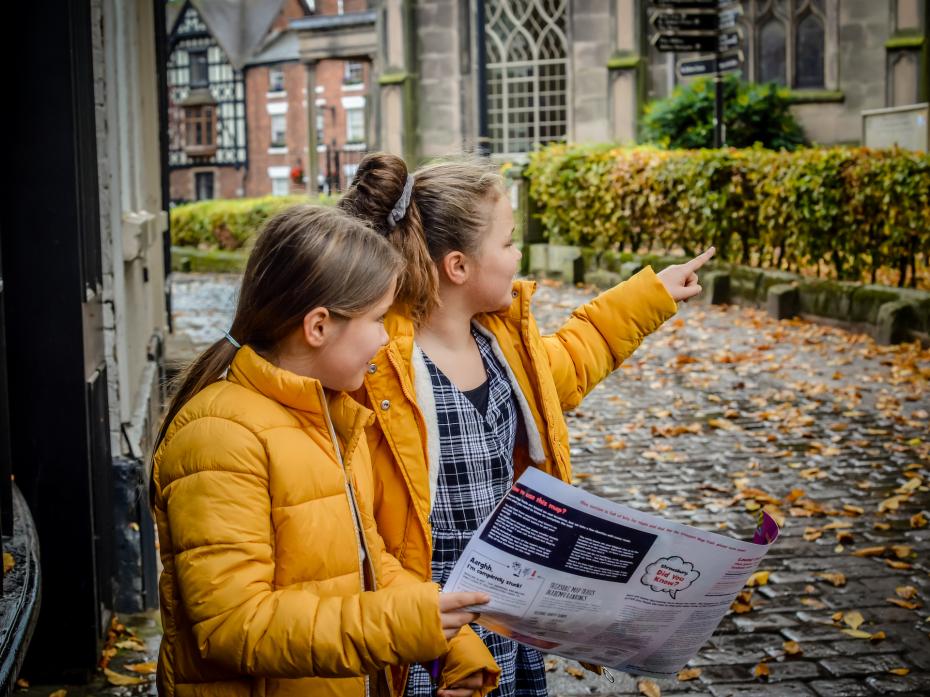 Girls using a map to find treasures in Shrewsbury